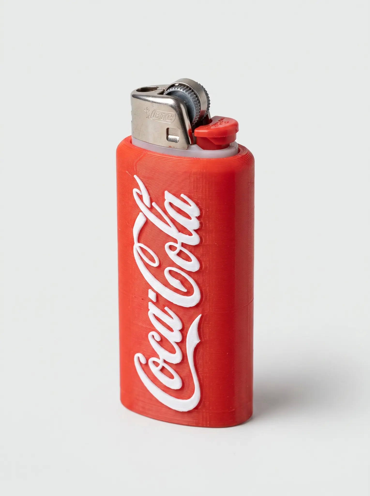 Classic-red 3D-printed lighter sleeve with raised white Coca-Cola script